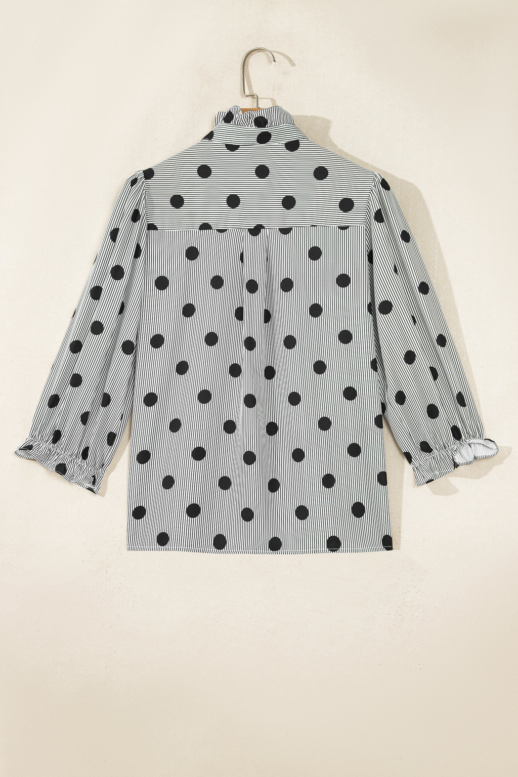 Camisa de manga tres cuartos con cuello alto, cuello alto y estampado de rayas y lunares rojos intensos.