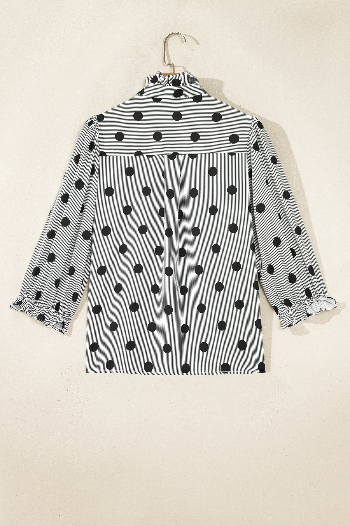 Camisa de manga tres cuartos con cuello alto, cuello alto y estampado de rayas y lunares rojos intensos.