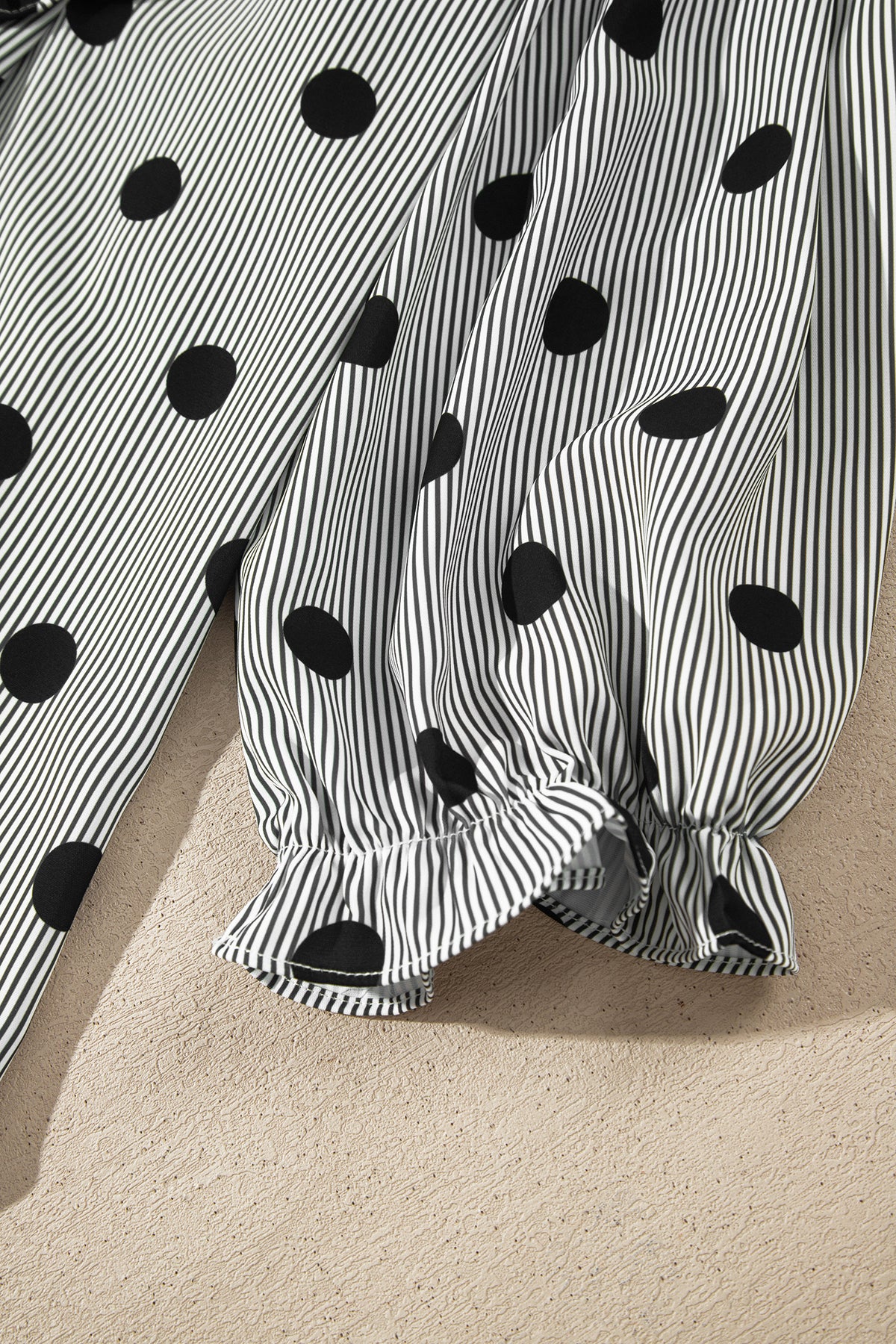 Camisa de manga tres cuartos con cuello alto, cuello alto y estampado de rayas y lunares rojos intensos.