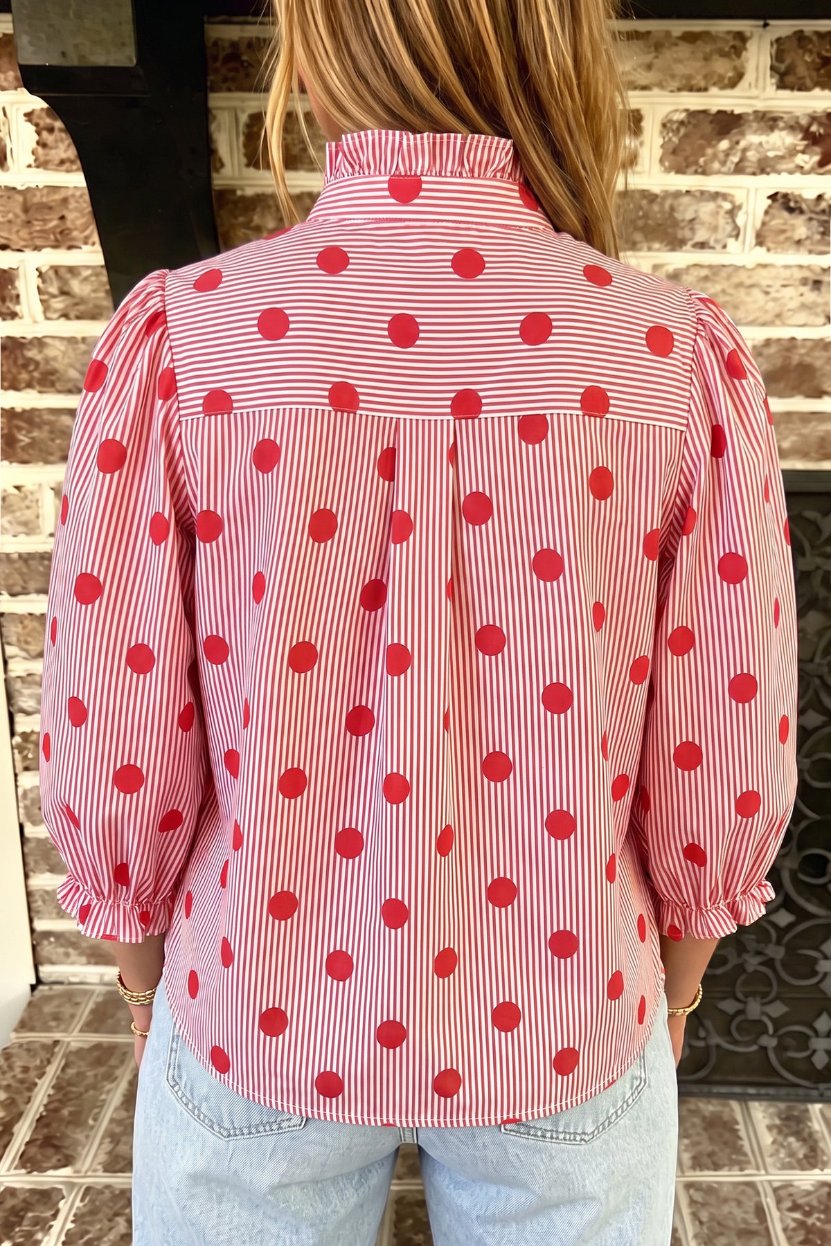 Camisa de manga tres cuartos con cuello alto, cuello alto y estampado de rayas y lunares rojos intensos.