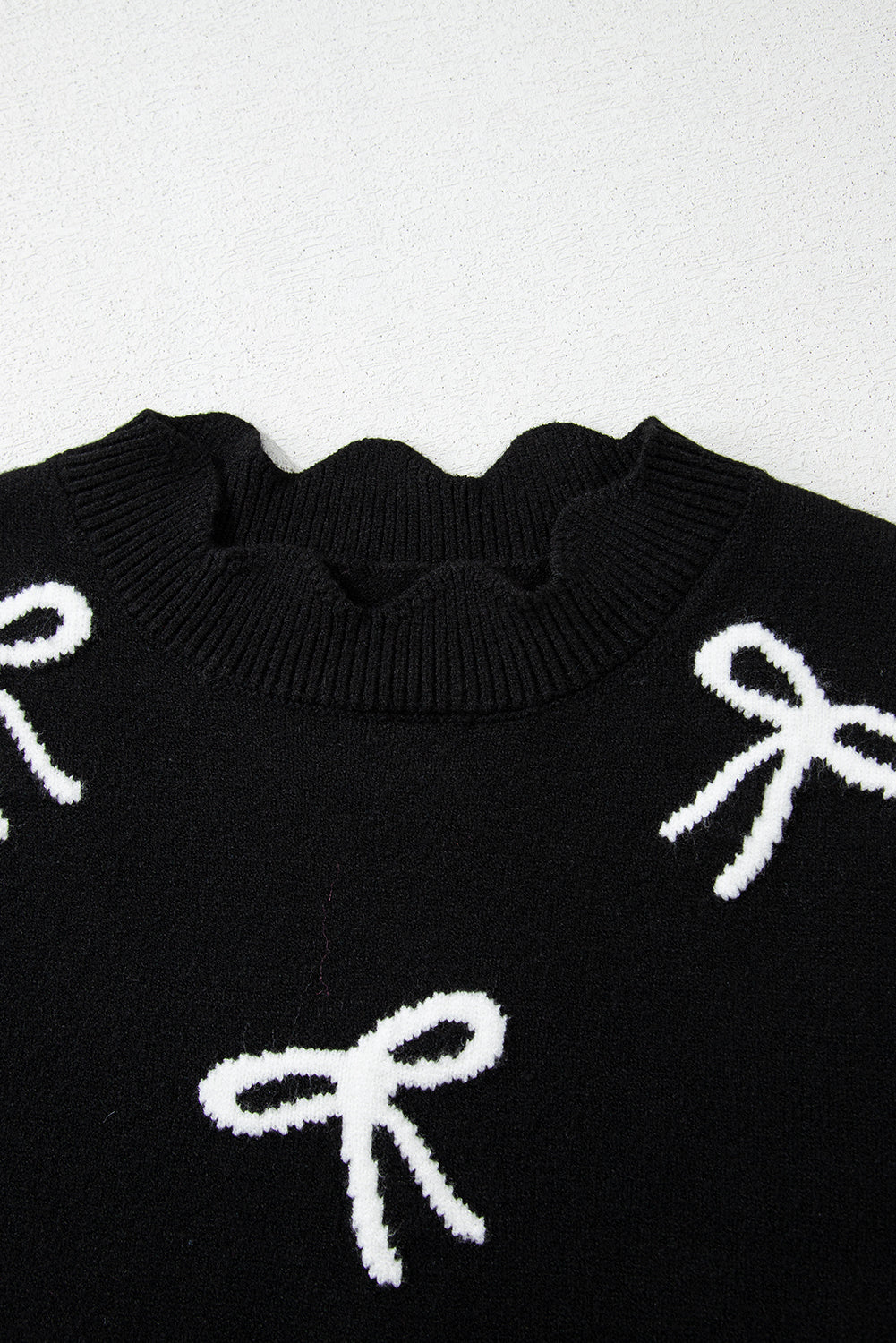Camiseta de punto con lazo negro, lazos laterales y bajo festoneado