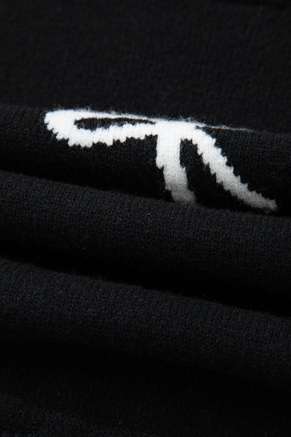 Camiseta de punto con lazo negro, lazos laterales y bajo festoneado