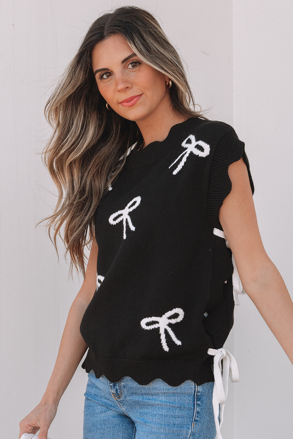 Camiseta de punto con lazo negro, lazos laterales y bajo festoneado