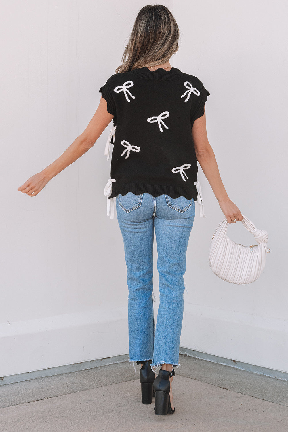 Camiseta de punto con lazo negro, lazos laterales y bajo festoneado