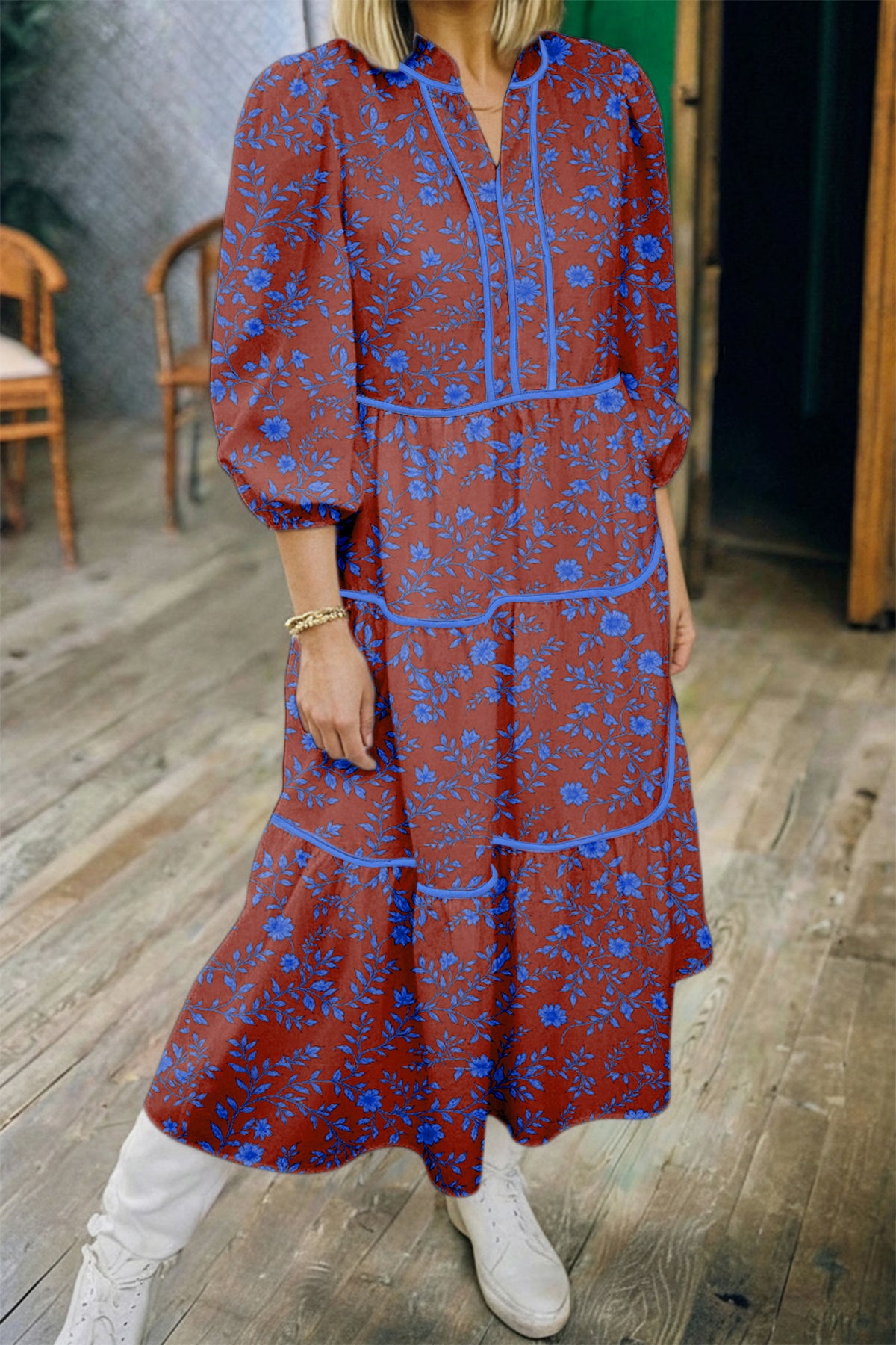Vestido holgado marrón con mangas tres cuartos abullonadas y volantes florales.