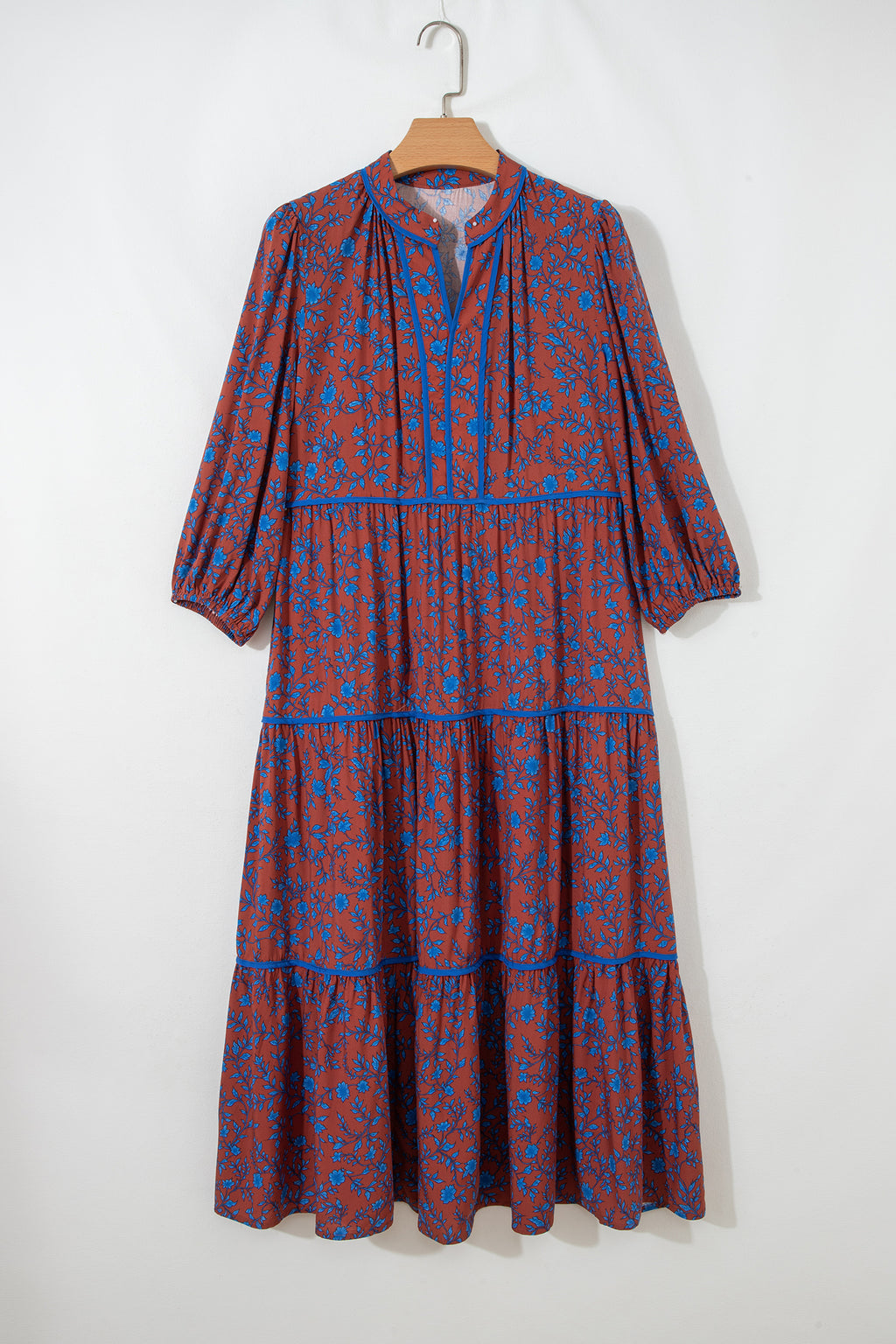 Vestido holgado marrón con mangas tres cuartos abullonadas y volantes florales.