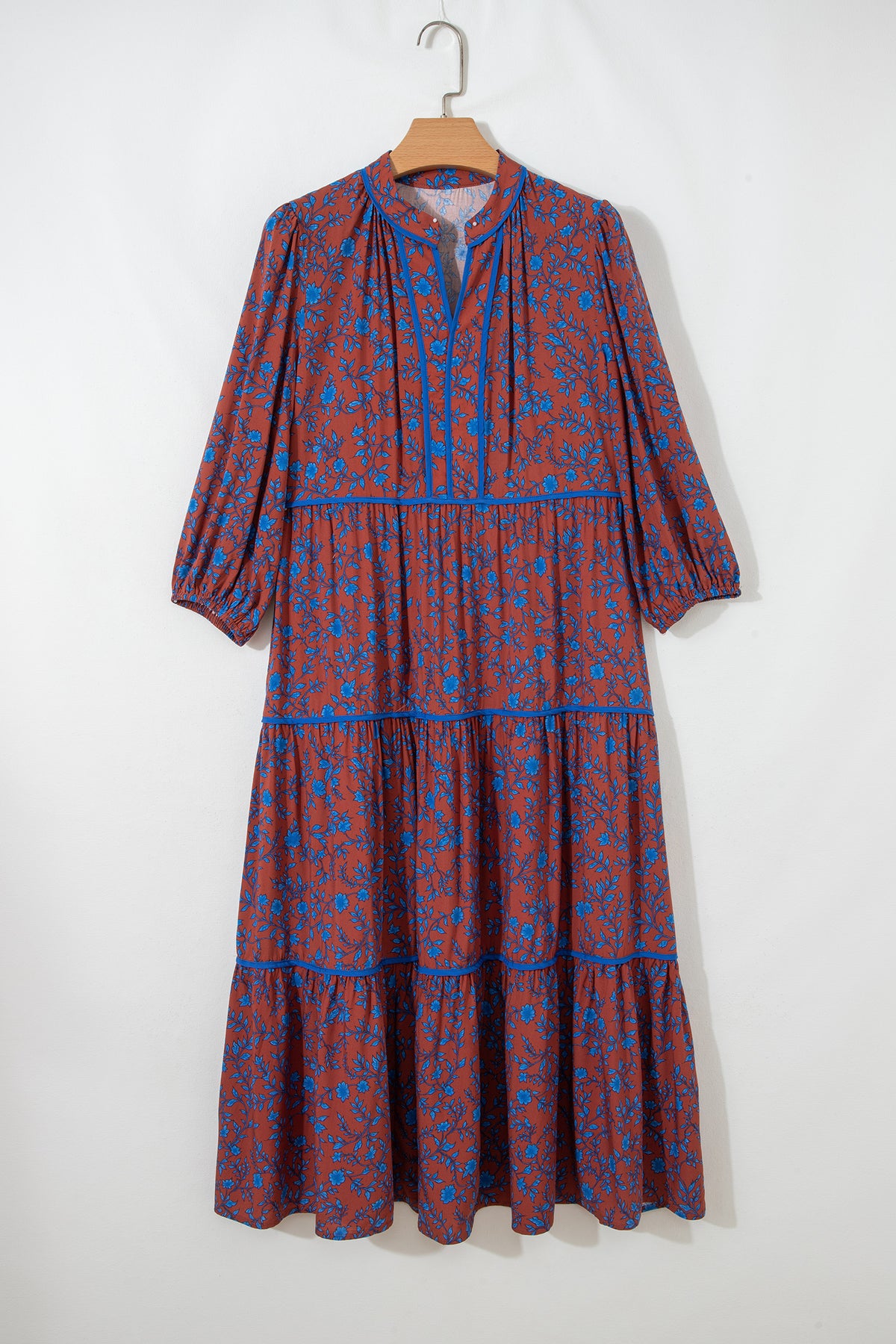 Vestido holgado marrón con mangas tres cuartos abullonadas y volantes florales.