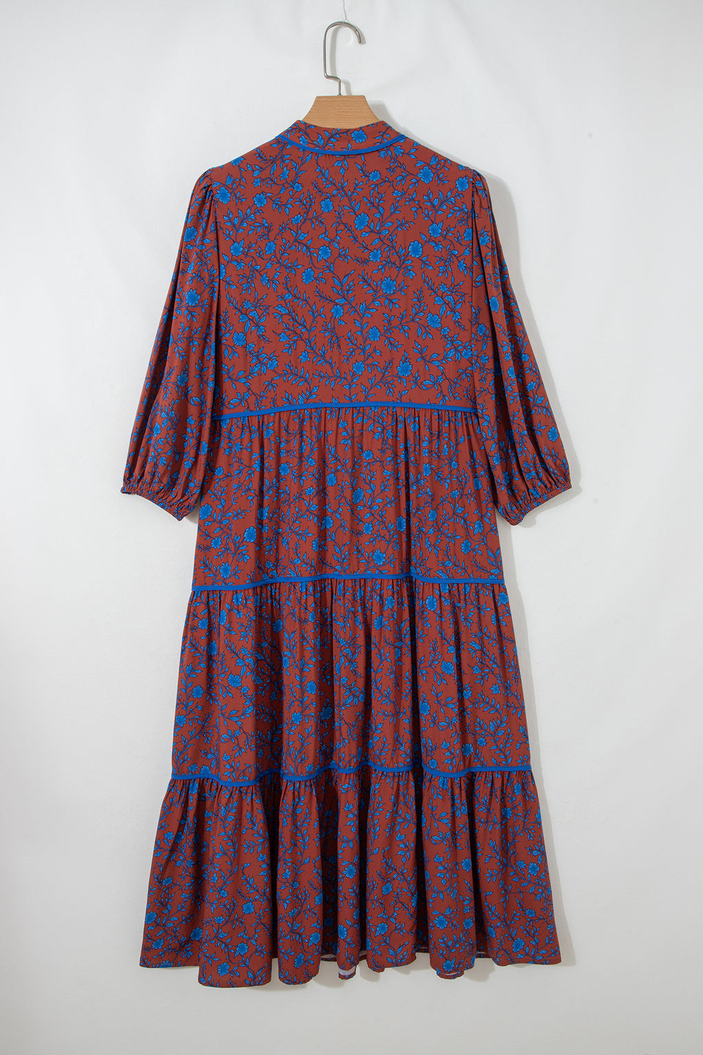 Vestido holgado marrón con mangas tres cuartos abullonadas y volantes florales.