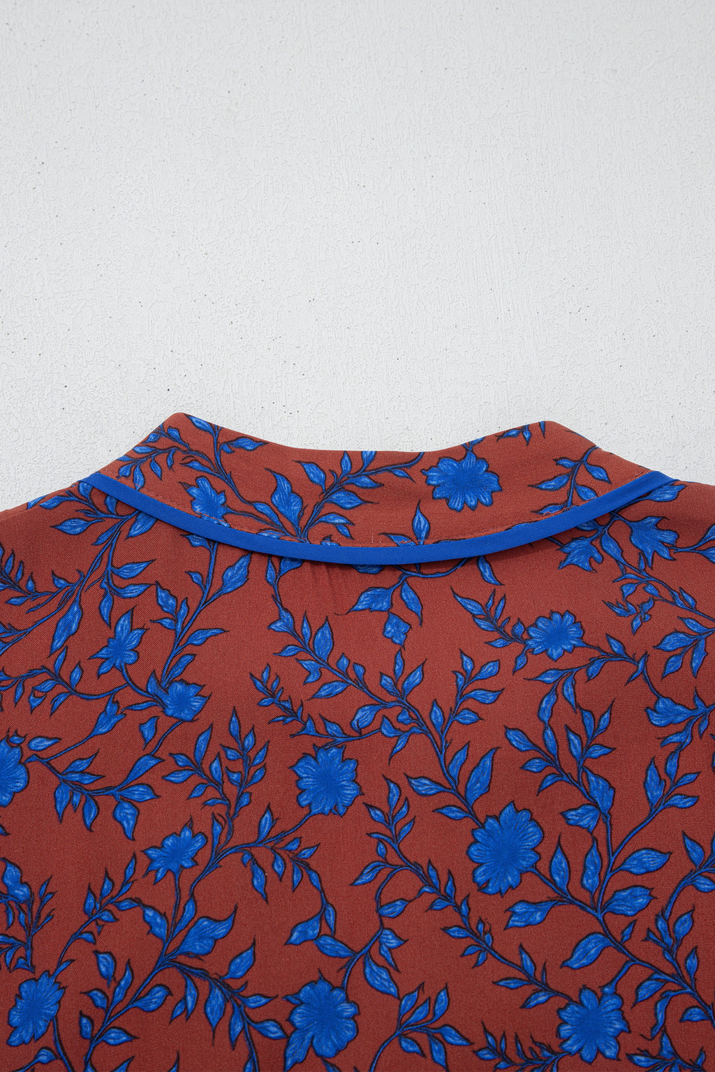 Vestido holgado marrón con mangas tres cuartos abullonadas y volantes florales.