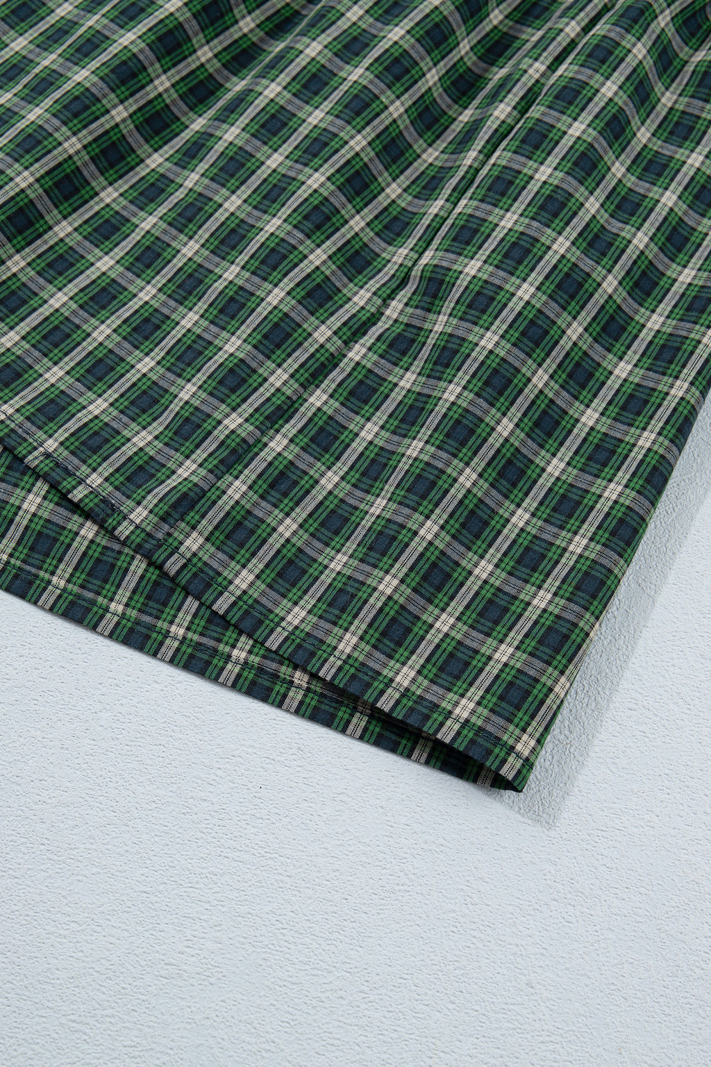 Vestido verde a cuadros con escote cuadrado, cintura alta fruncida y bajo con volantes.