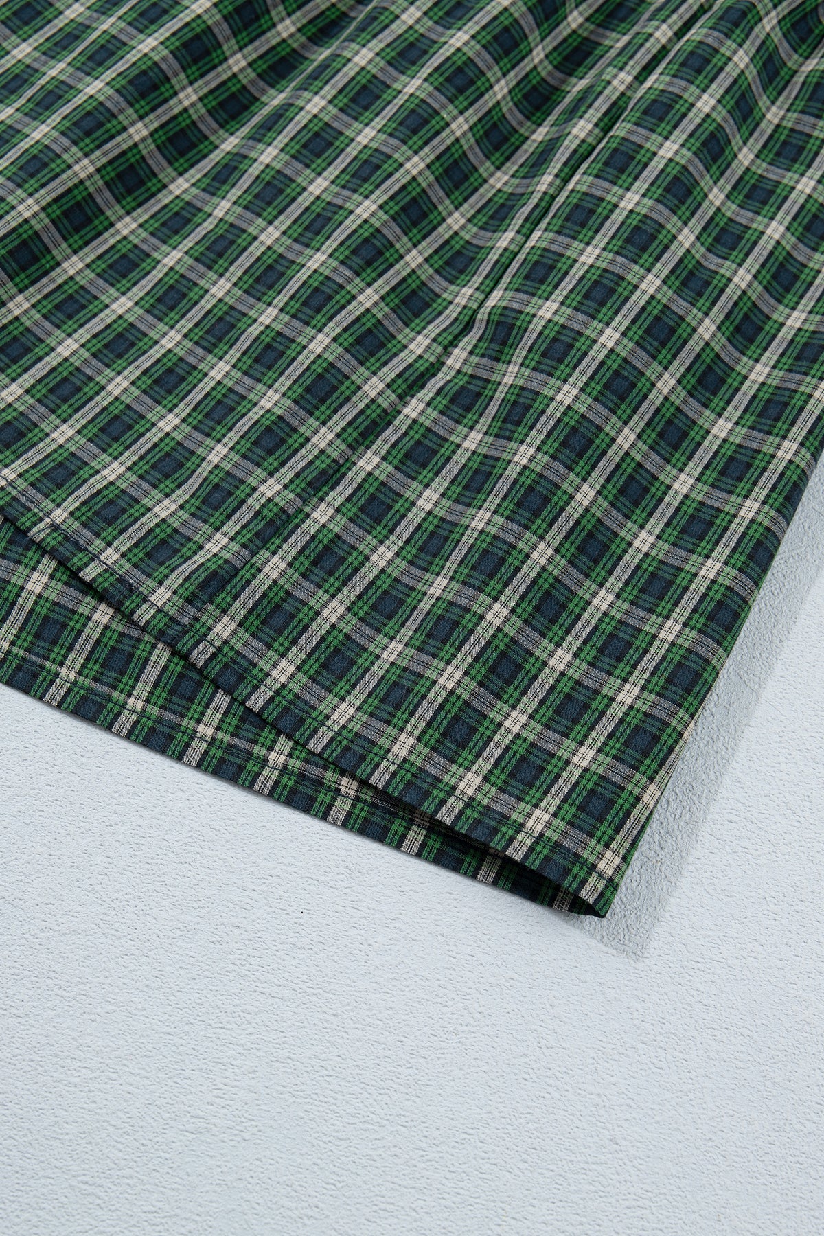 Vestido verde a cuadros con escote cuadrado, cintura alta fruncida y bajo con volantes.