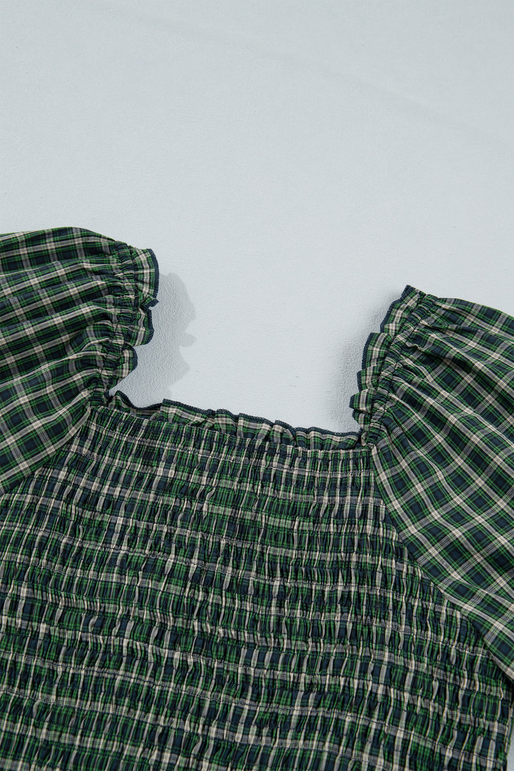 Vestido verde a cuadros con escote cuadrado, cintura alta fruncida y bajo con volantes.