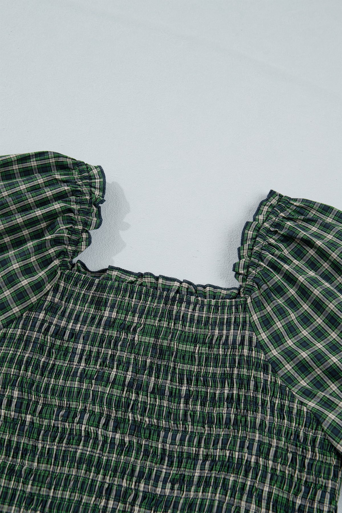 Vestido verde a cuadros con escote cuadrado, cintura alta fruncida y bajo con volantes.
