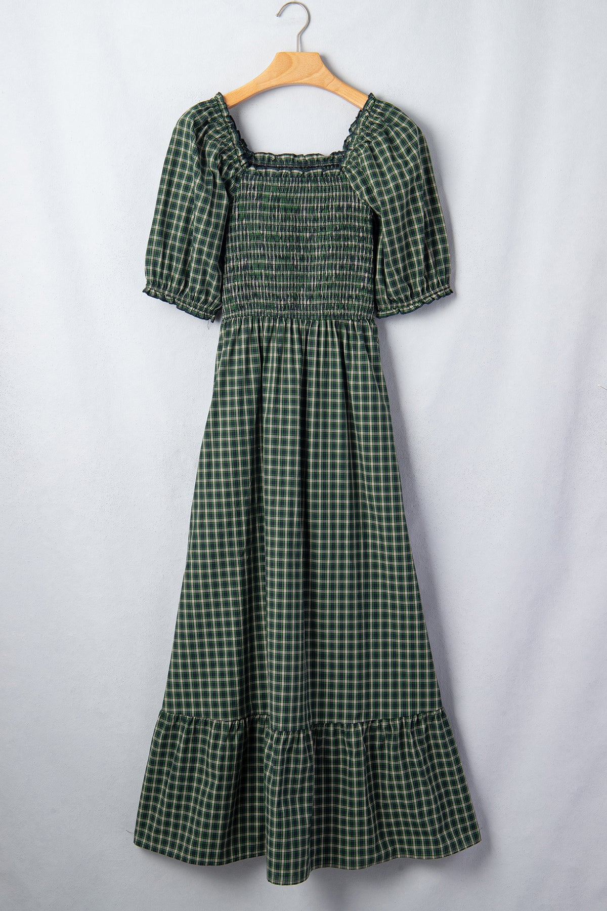 Vestido verde a cuadros con escote cuadrado, cintura alta fruncida y bajo con volantes.