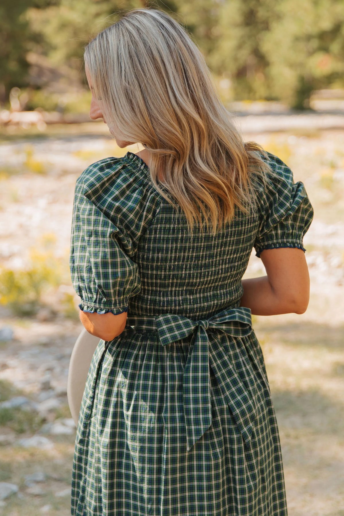 Vestido verde a cuadros con escote cuadrado, cintura alta fruncida y bajo con volantes.