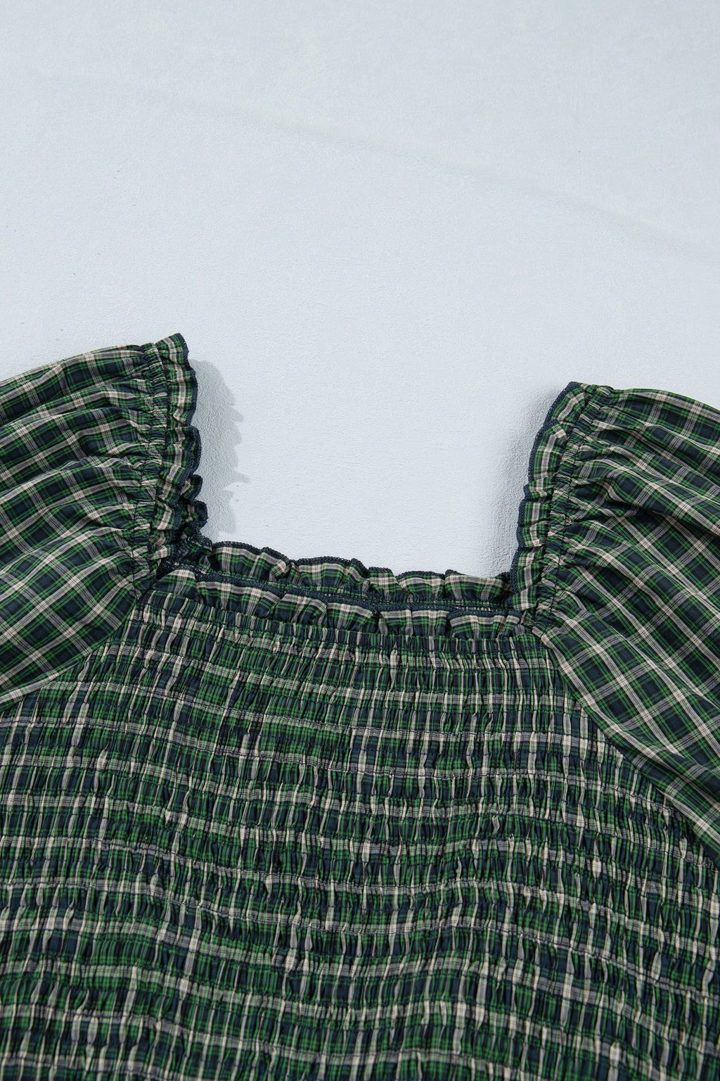 Vestido verde a cuadros con escote cuadrado, cintura alta fruncida y bajo con volantes.