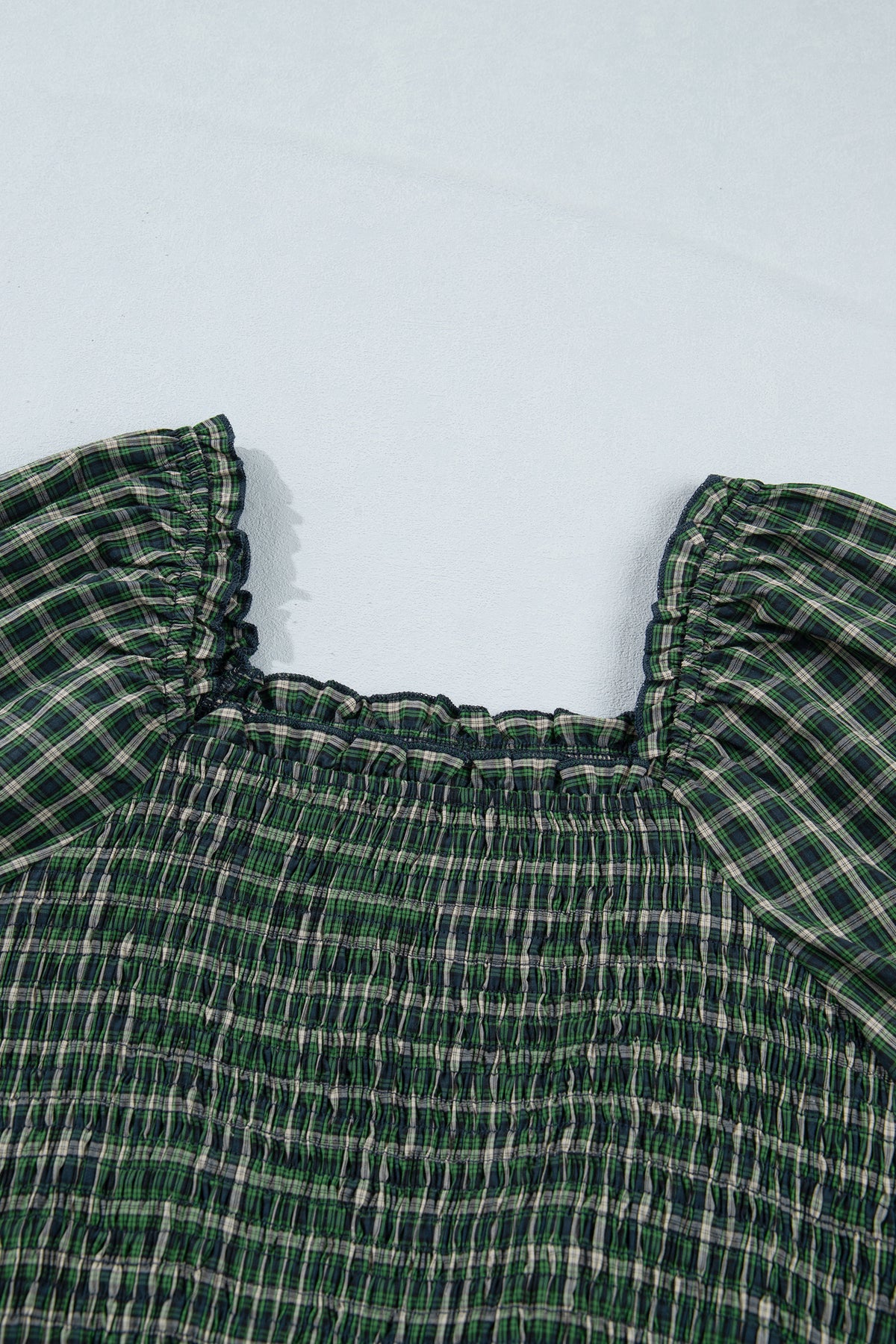 Vestido verde a cuadros con escote cuadrado, cintura alta fruncida y bajo con volantes.