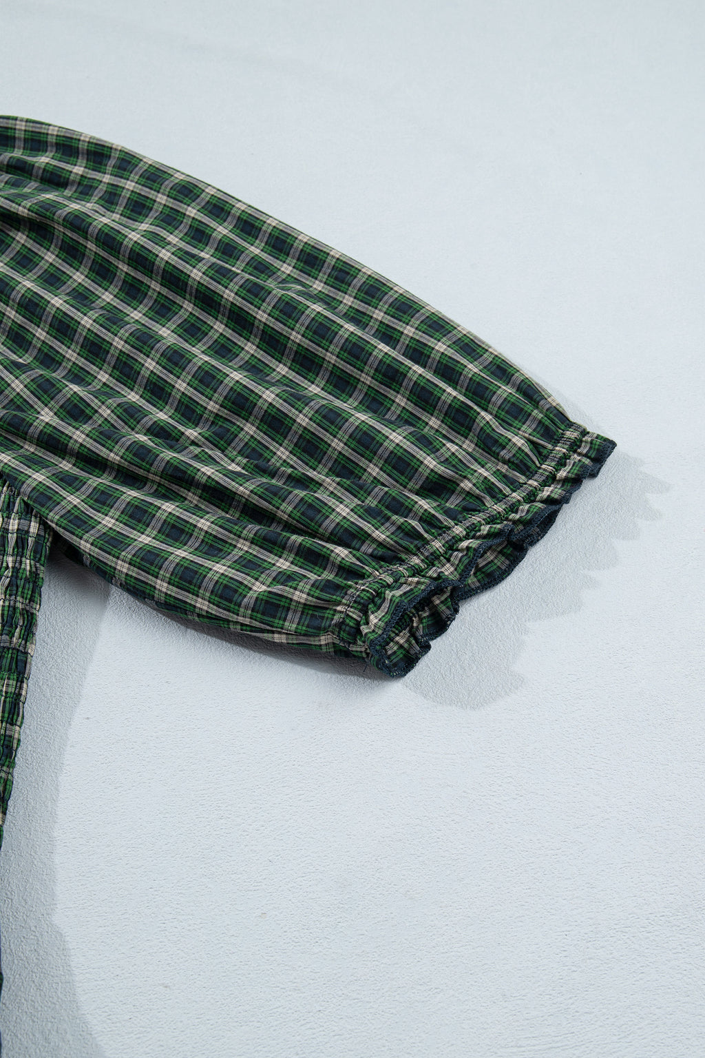 Vestido verde a cuadros con escote cuadrado, cintura alta fruncida y bajo con volantes.