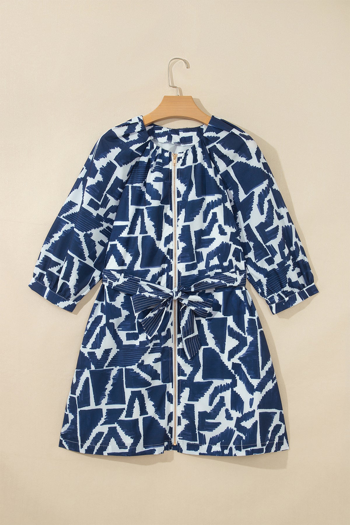 Vestido recto azul con estampado geométrico abstracto, cremallera frontal y lazo en la cintura.