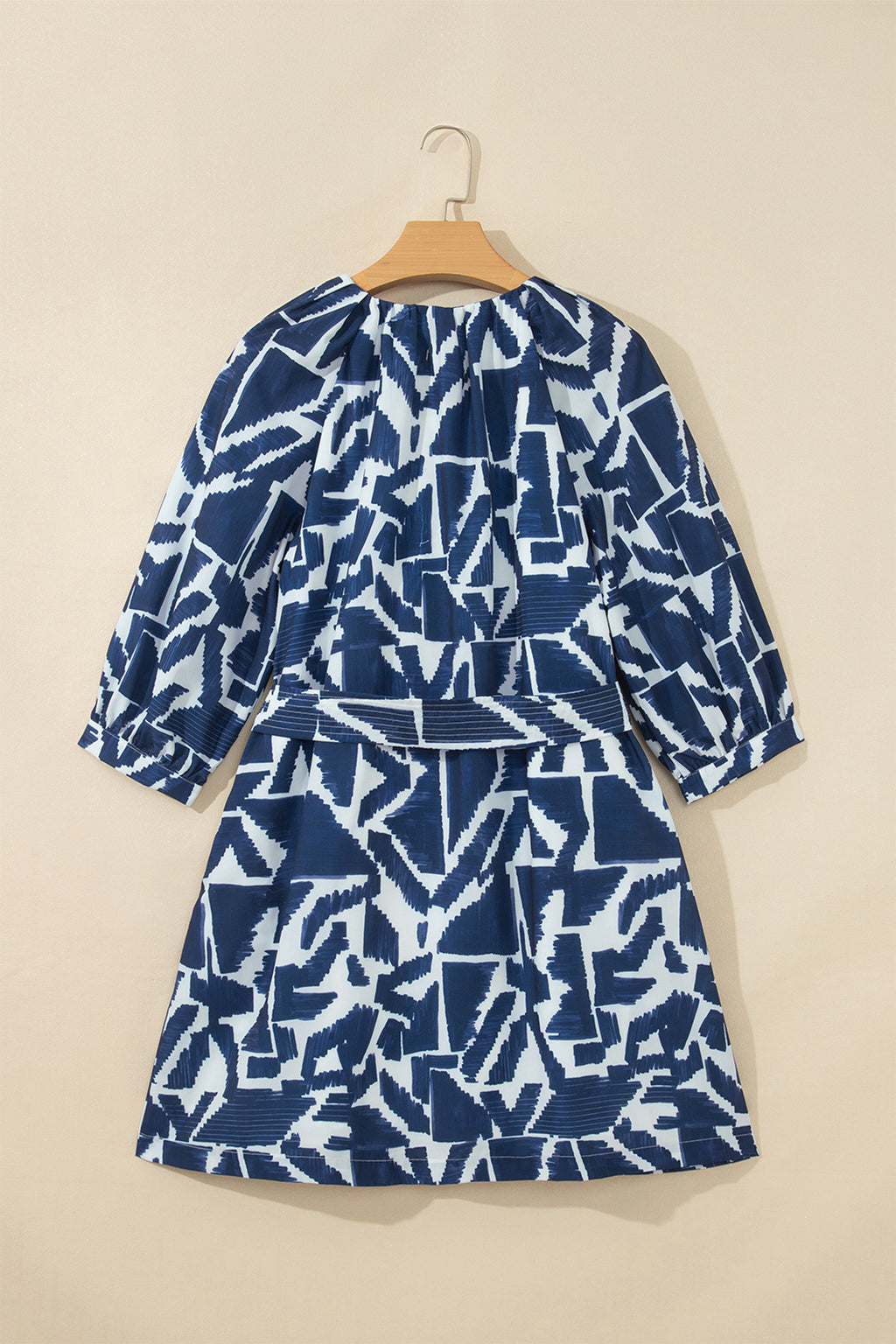 Vestido recto azul con estampado geométrico abstracto, cremallera frontal y lazo en la cintura.