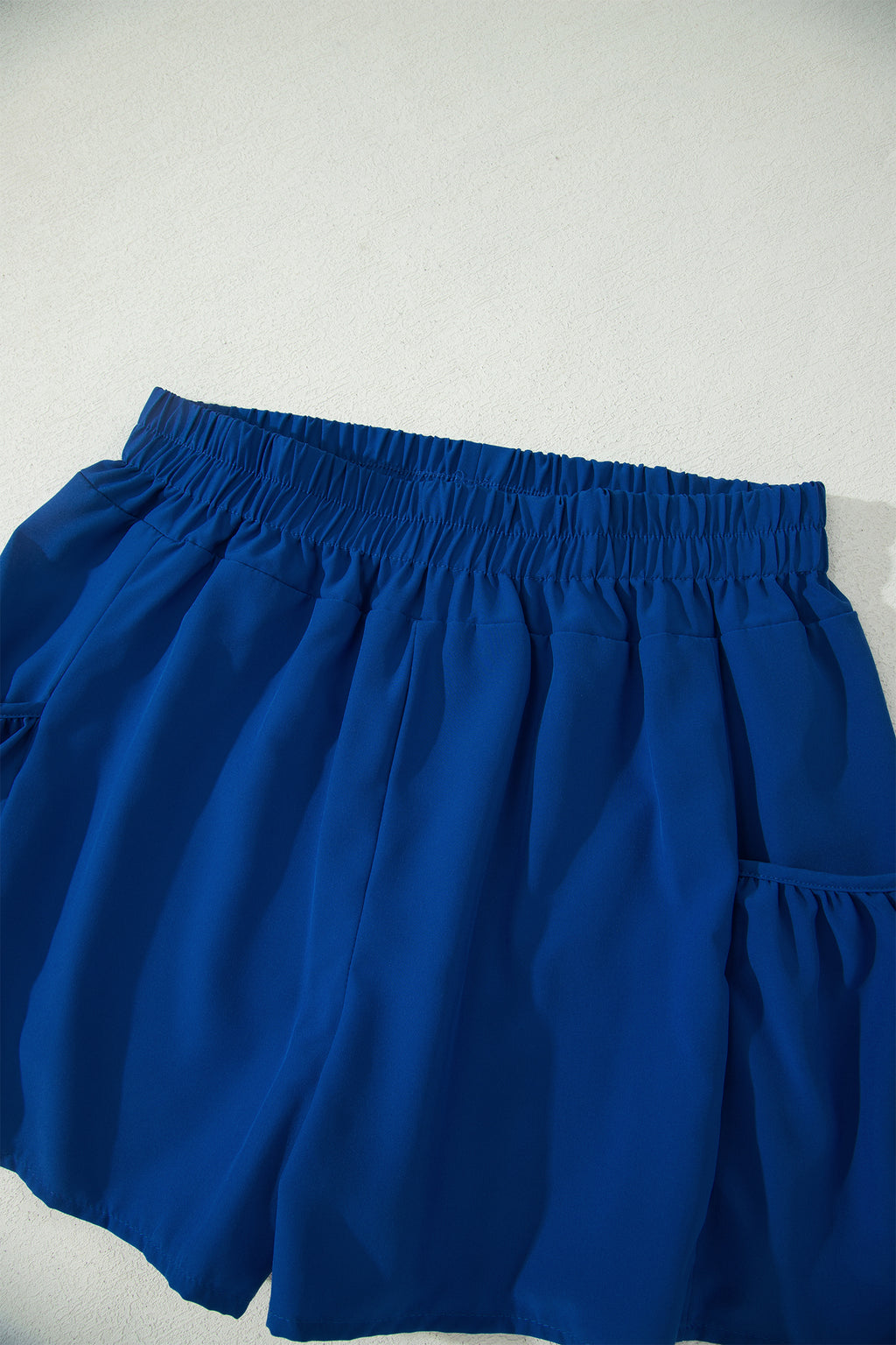 Conjunto de camiseta sin mangas ajustada de canalé azul oscuro y shorts de pierna ancha con bolsillos.