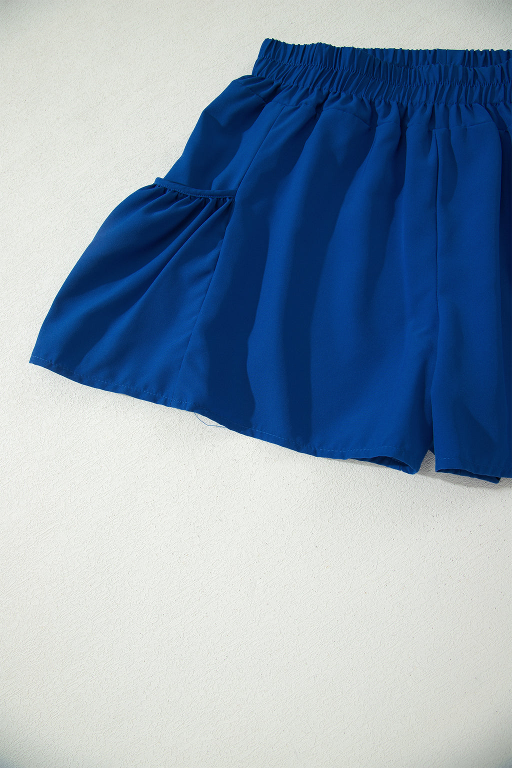 Conjunto de camiseta sin mangas ajustada de canalé azul oscuro y shorts de pierna ancha con bolsillos.