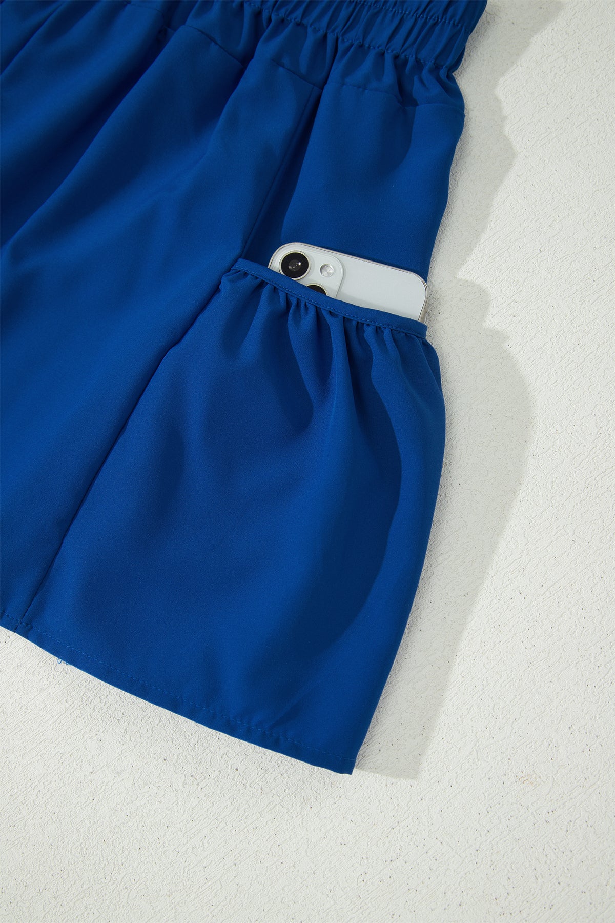 Conjunto de camiseta sin mangas ajustada de canalé azul oscuro y shorts de pierna ancha con bolsillos.