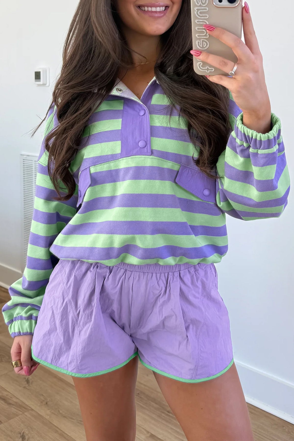 Conjunto de 2 piezas: top de manga larga con medio botón y rayas moradas, y shorts combinables.