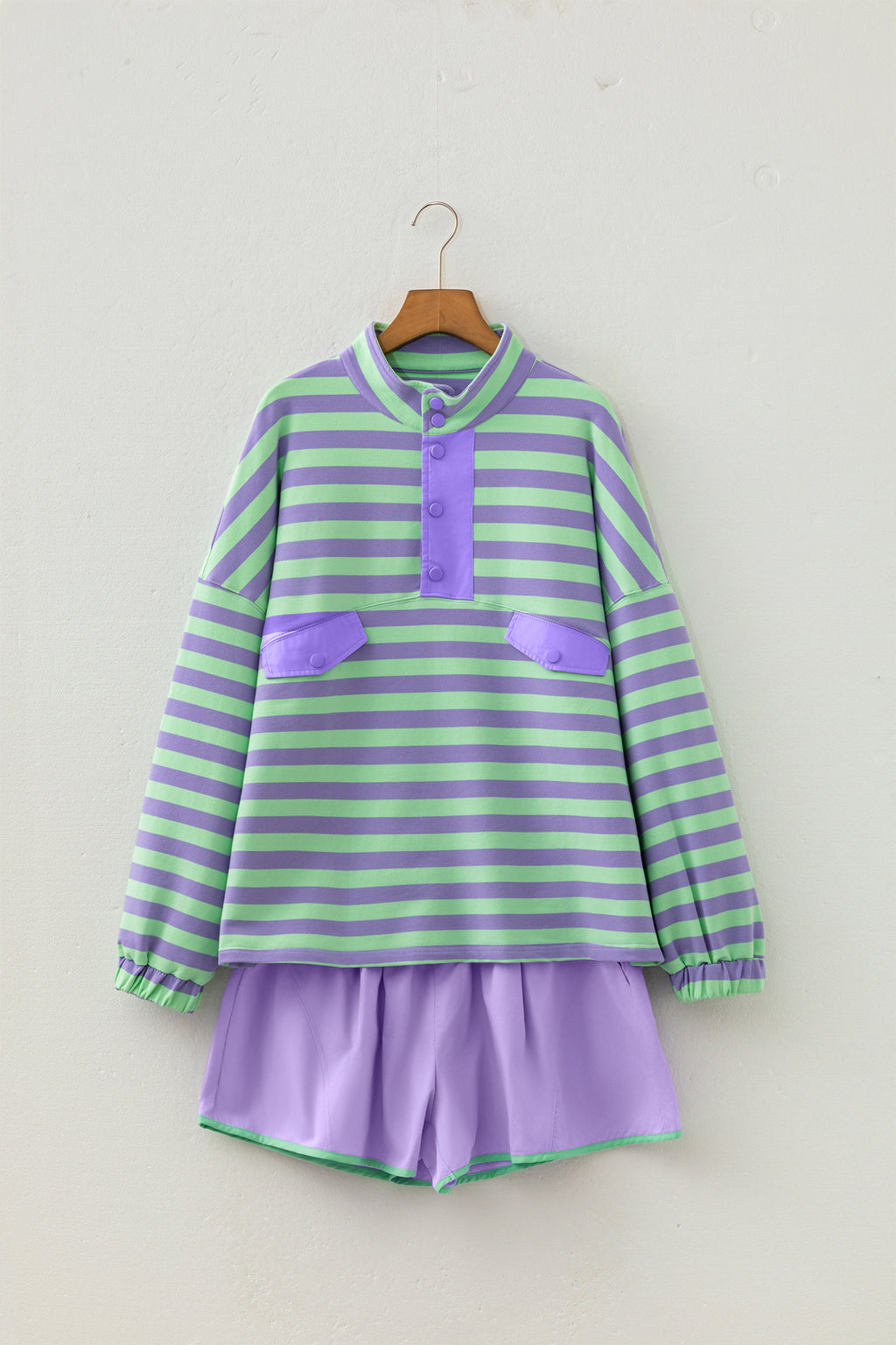 Conjunto de 2 piezas: top de manga larga con medio botón y rayas moradas, y shorts combinables.