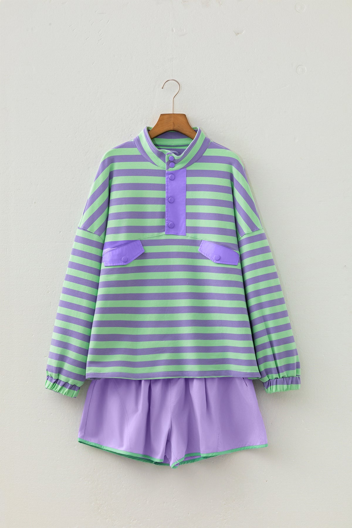 Conjunto de 2 piezas: top de manga larga con medio botón y rayas moradas, y shorts combinables.