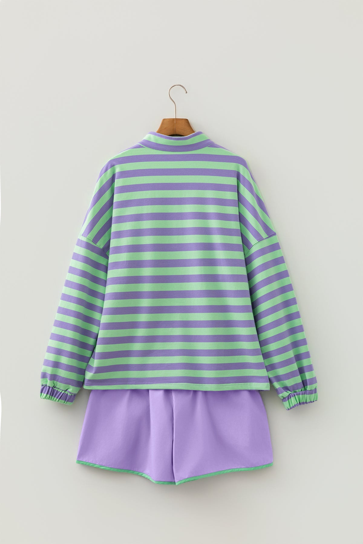 Conjunto de 2 piezas: top de manga larga con medio botón y rayas moradas, y shorts combinables.