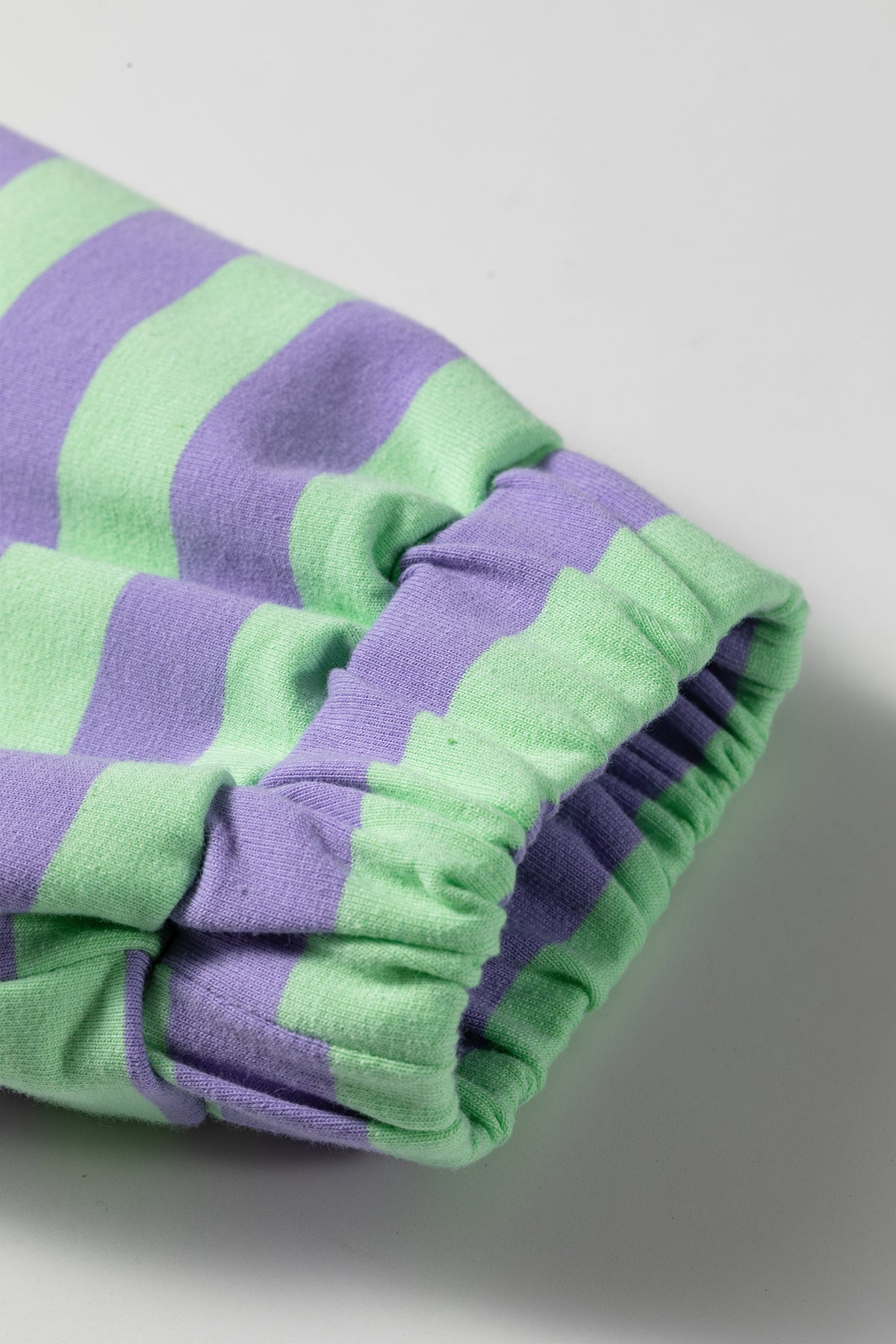 Conjunto de 2 piezas: top de manga larga con medio botón y rayas moradas, y shorts combinables.