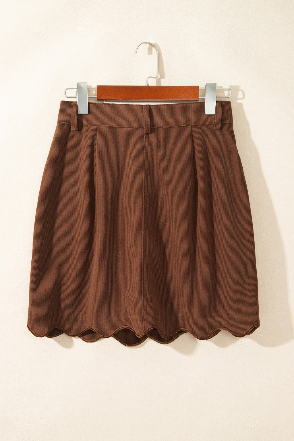 Falda de pana con botones delanteros y mini bolsillos, silueta ajustada.