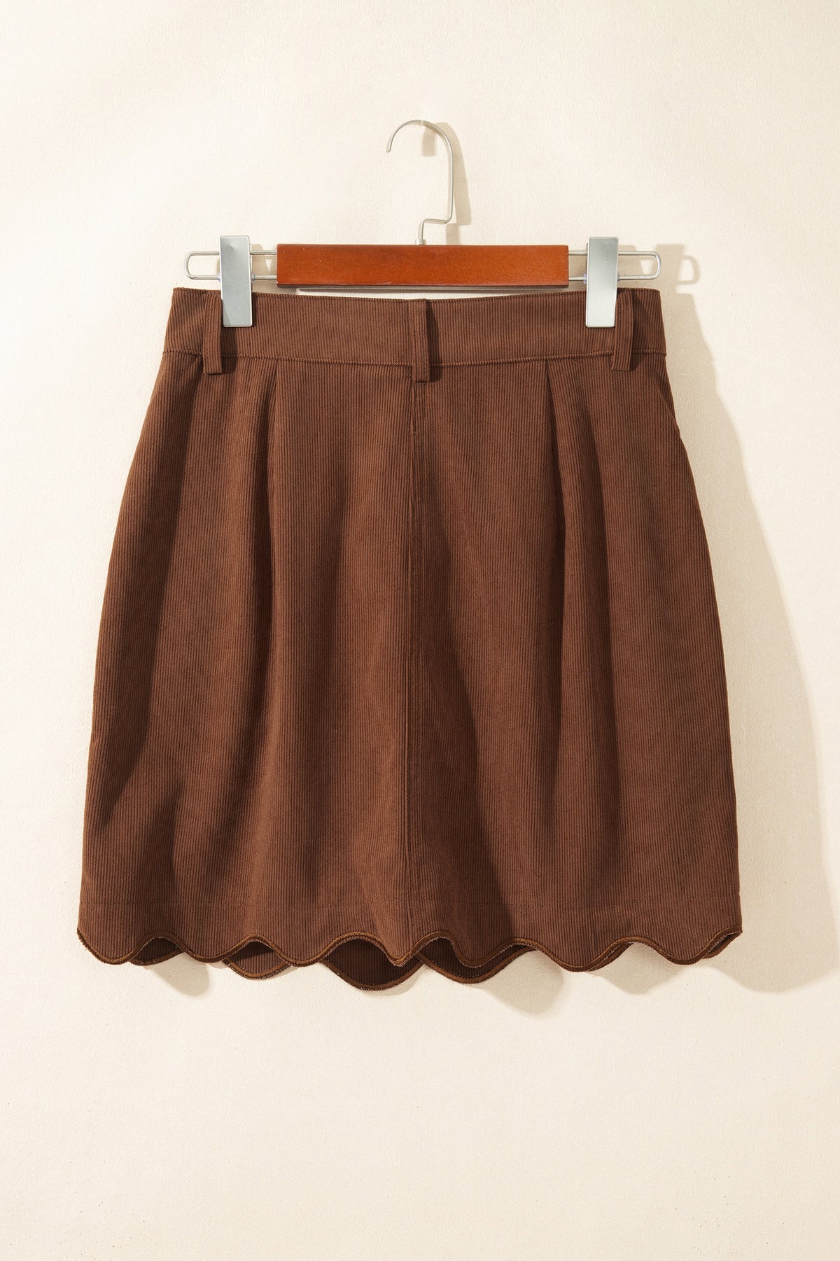 Falda de pana con botones delanteros y mini bolsillos, silueta ajustada.
