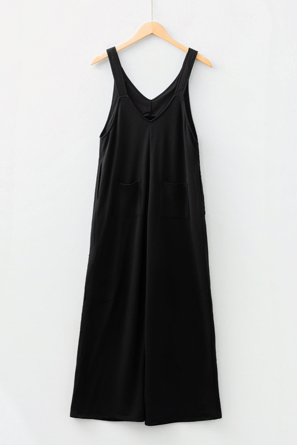Mono holgado negro liso con costuras sin rematar y parches de flores grandes.