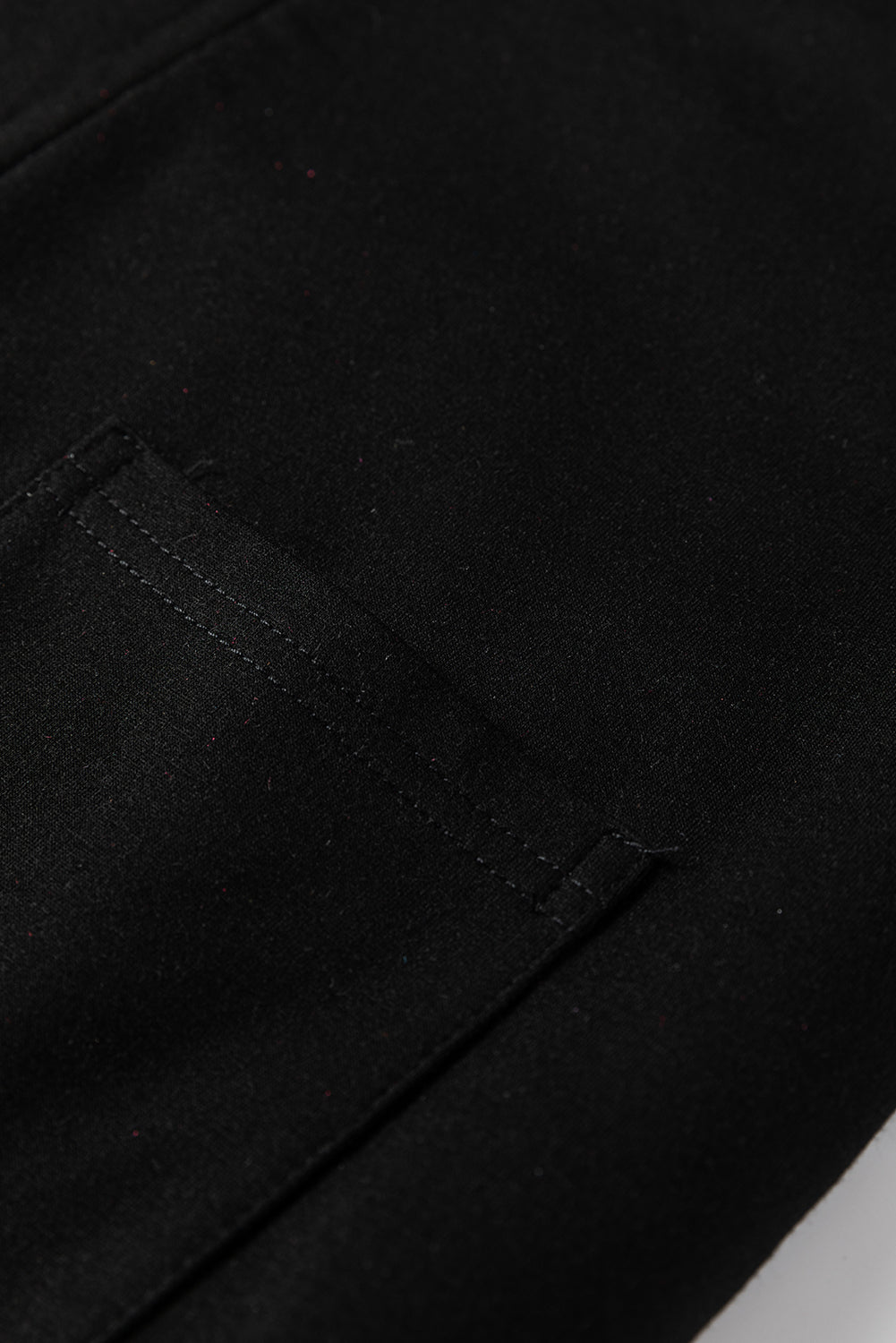 Mono holgado negro liso con costuras sin rematar y parches de flores grandes.