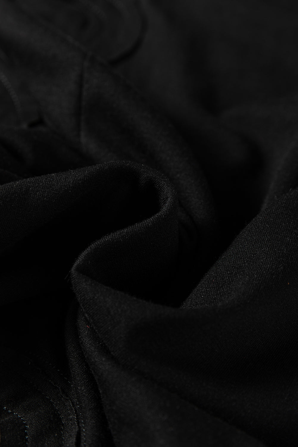 Mono holgado negro liso con costuras sin rematar y parches de flores grandes.