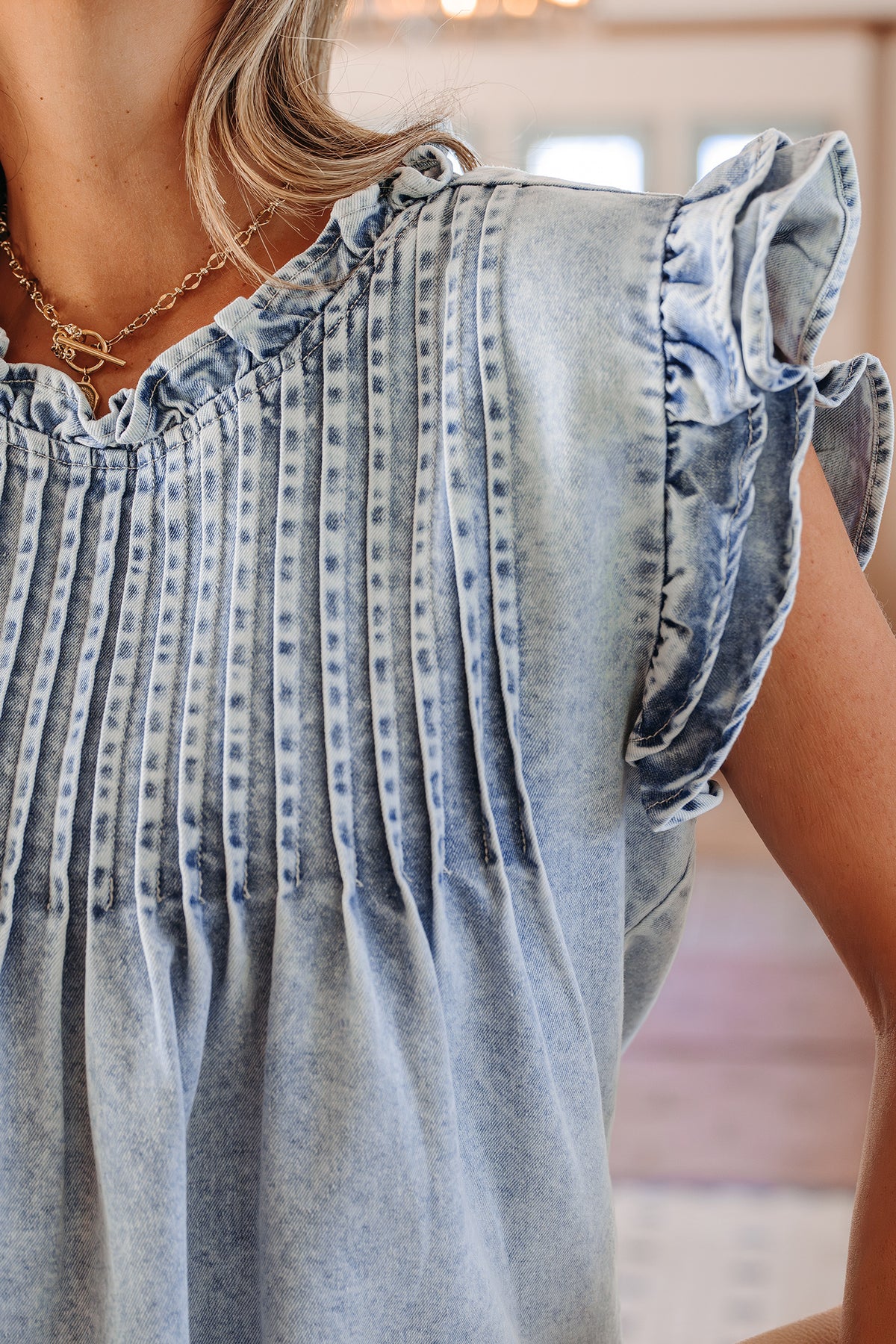 Top vaquero vintage lavado con volantes y detalles plisados en color azul Beau.
