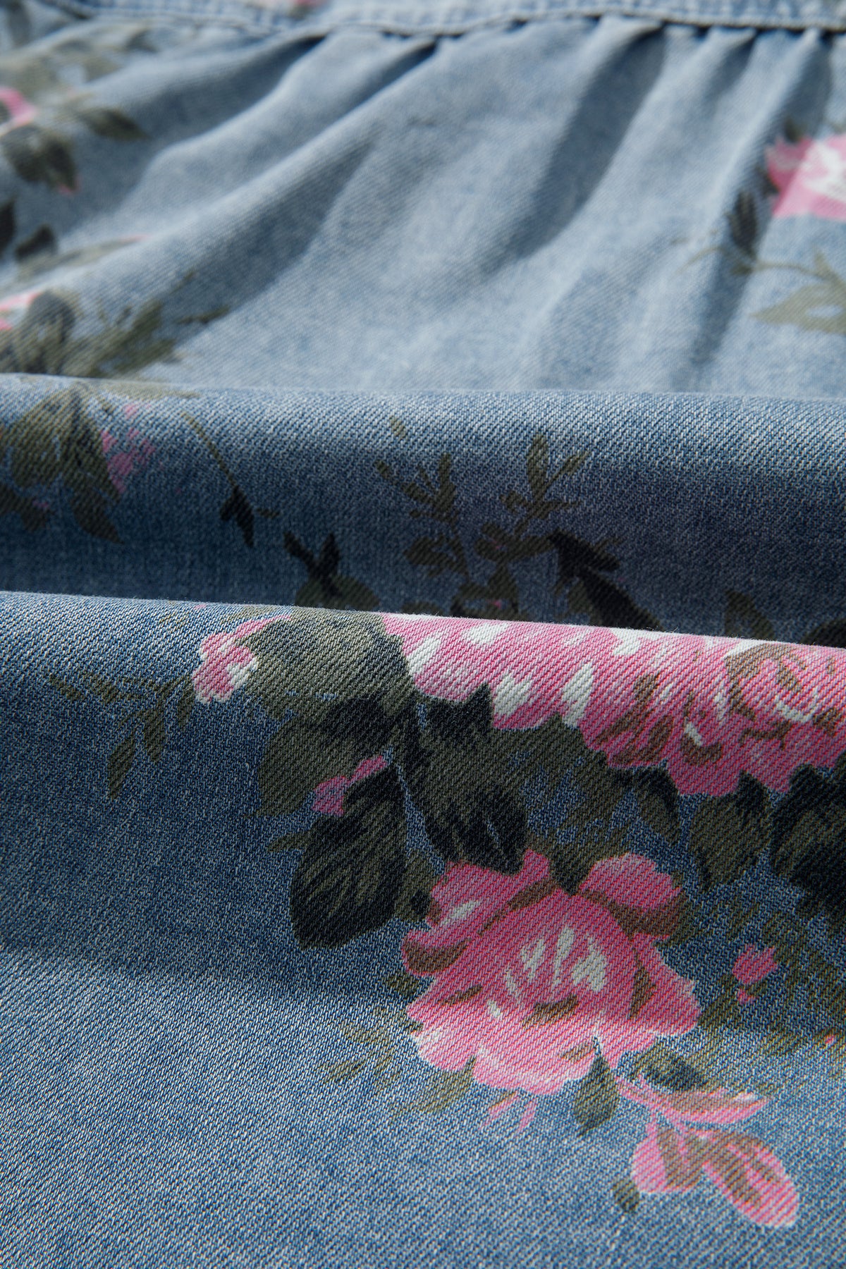 Camisa vaquera azul con mangas tipo brazalete y estampado floral.