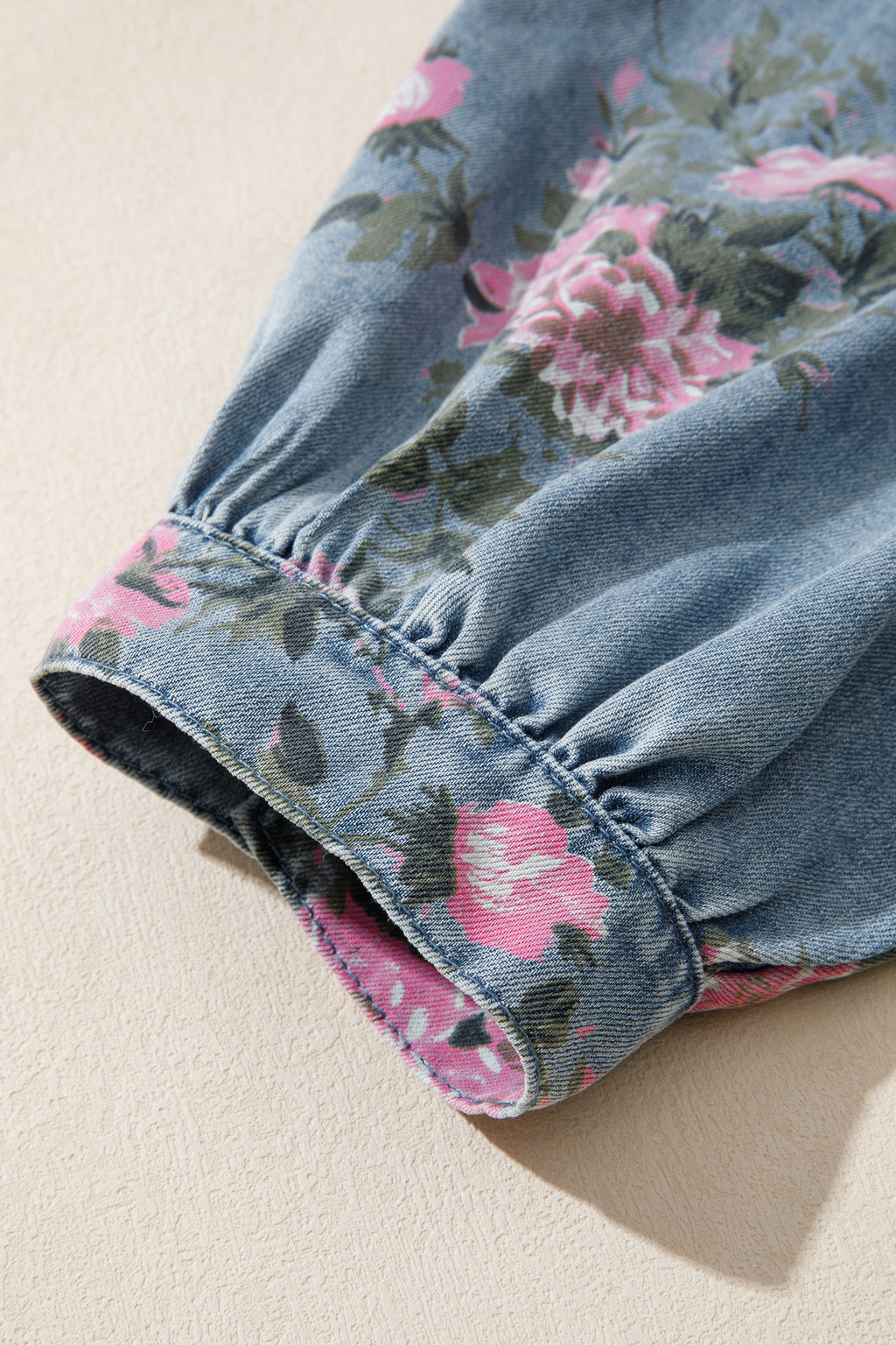 Camisa vaquera azul con mangas tipo brazalete y estampado floral.