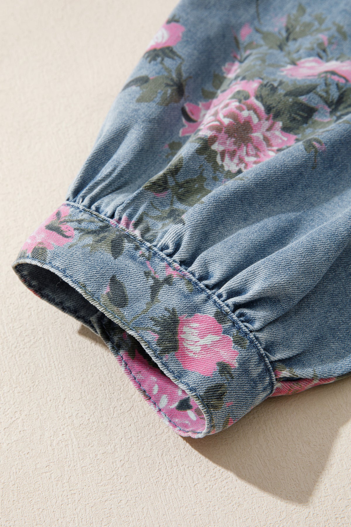 Camisa vaquera azul con mangas tipo brazalete y estampado floral.