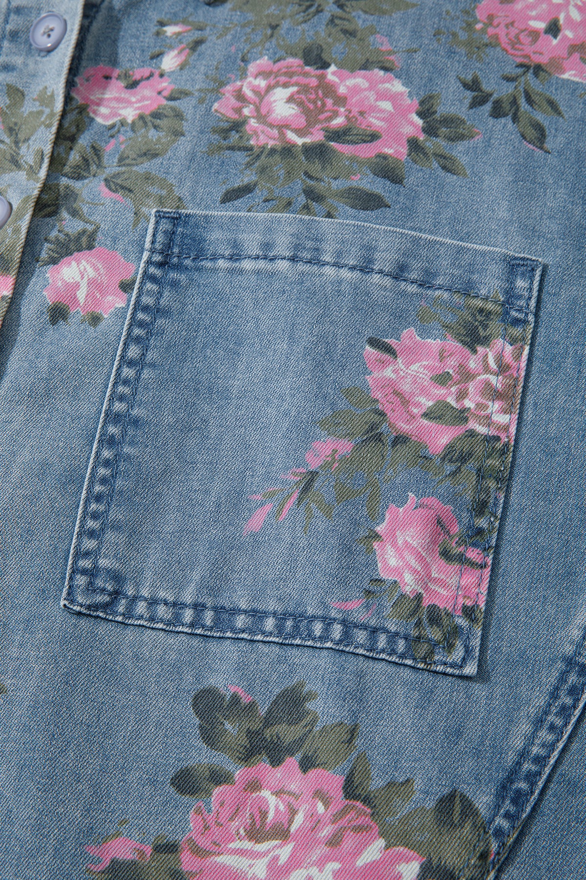 Camisa vaquera azul con mangas tipo brazalete y estampado floral.