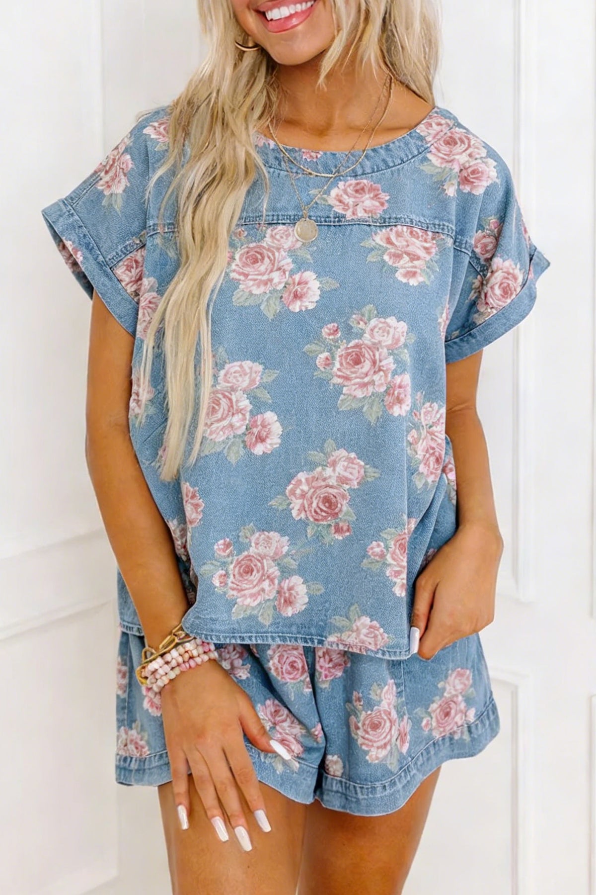 Conjunto de 2 piezas: top de manga corta de mezclilla azul cielo con estampado floral y shorts holgados.