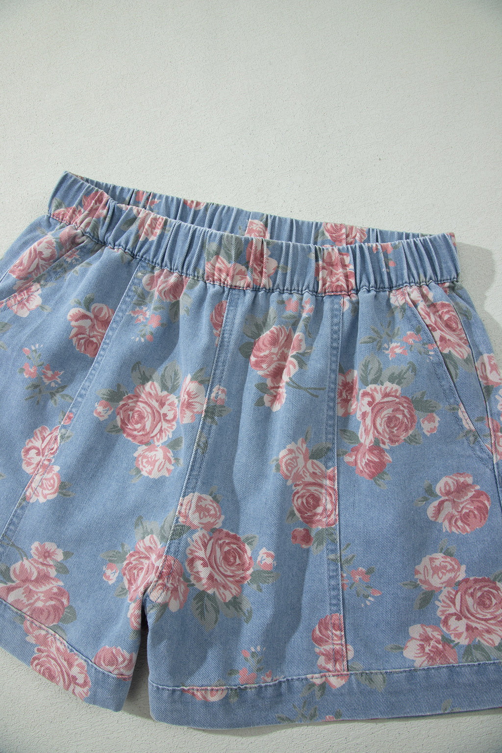 Conjunto de 2 piezas: top de manga corta de mezclilla azul cielo con estampado floral y shorts holgados.