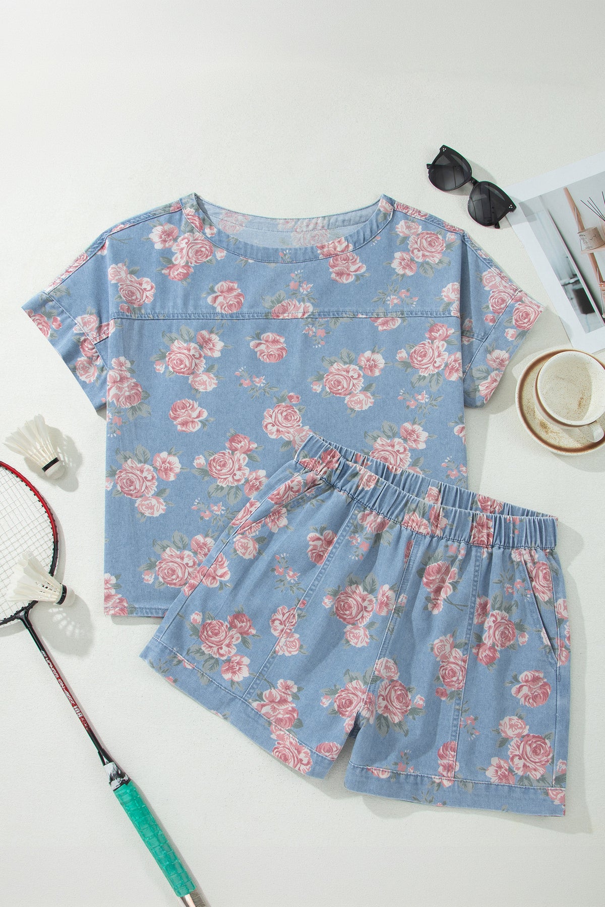 Conjunto de 2 piezas: top de manga corta de mezclilla azul cielo con estampado floral y shorts holgados.