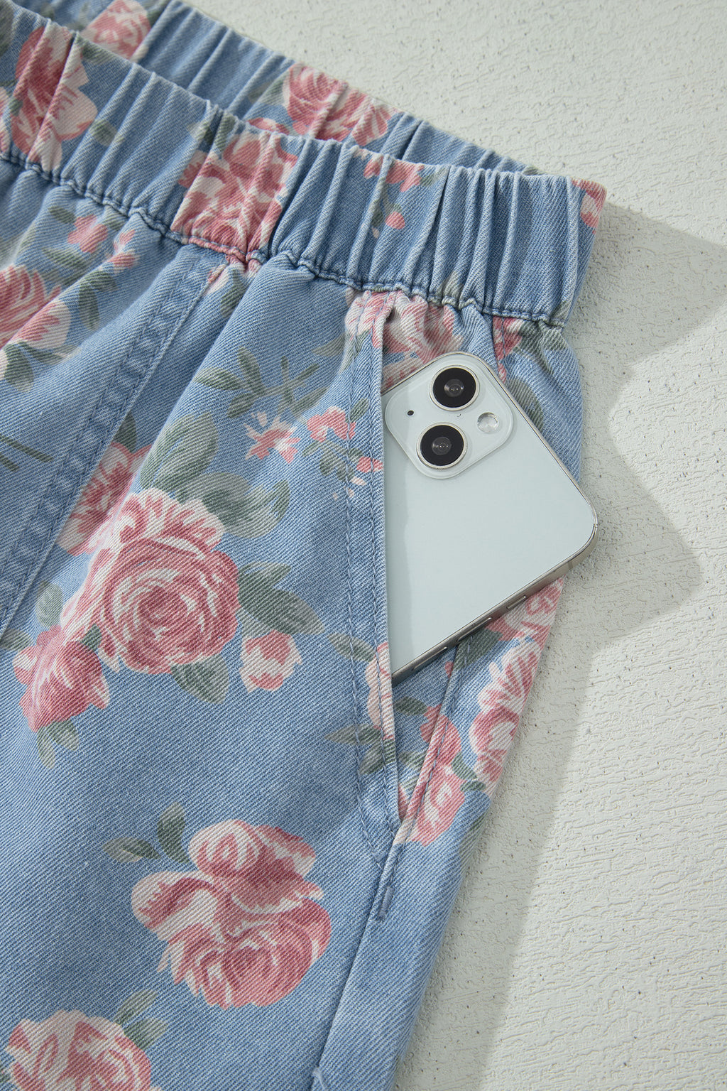 Conjunto de 2 piezas: top de manga corta de mezclilla azul cielo con estampado floral y shorts holgados.