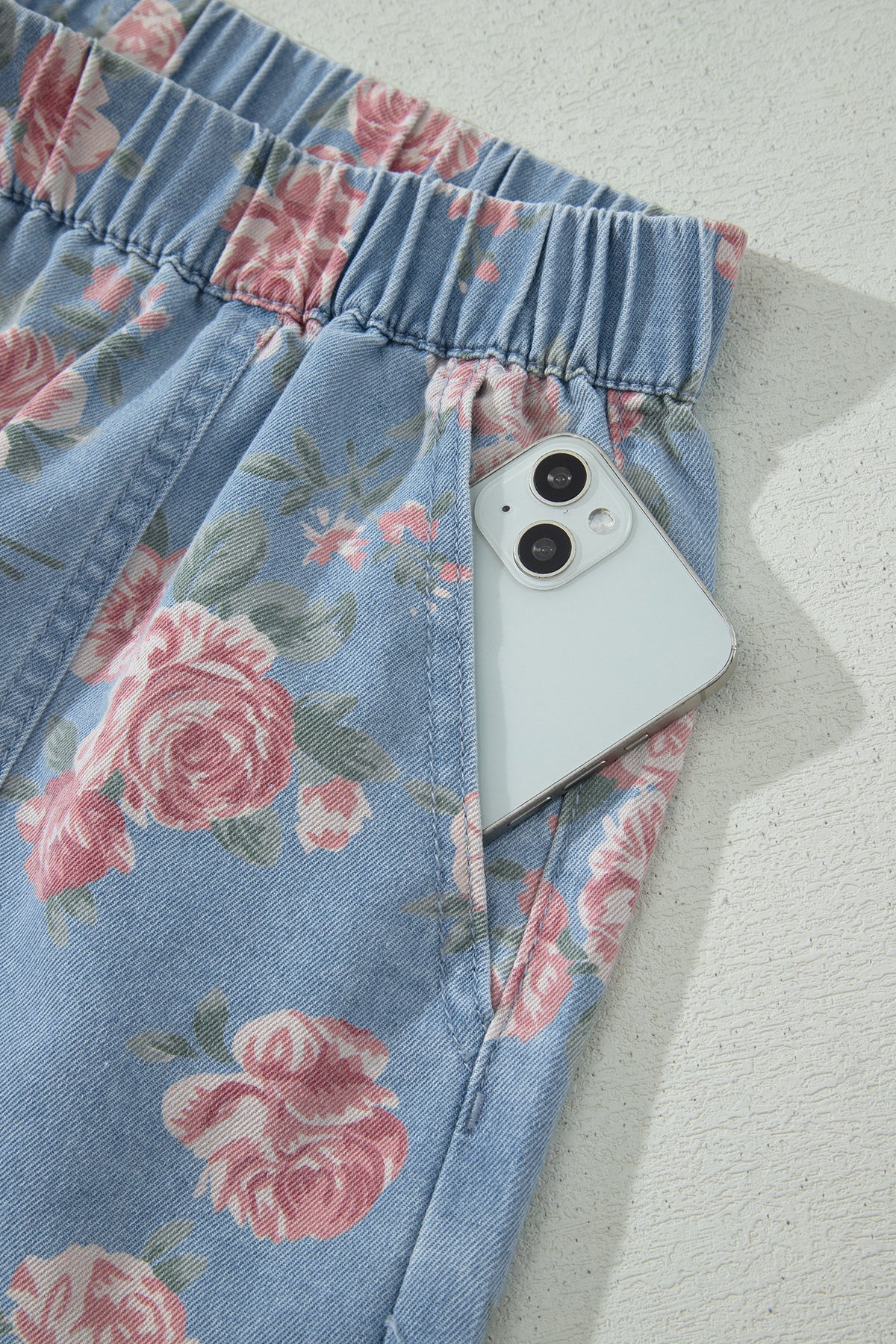 Conjunto de 2 piezas: top de manga corta de mezclilla azul cielo con estampado floral y shorts holgados.