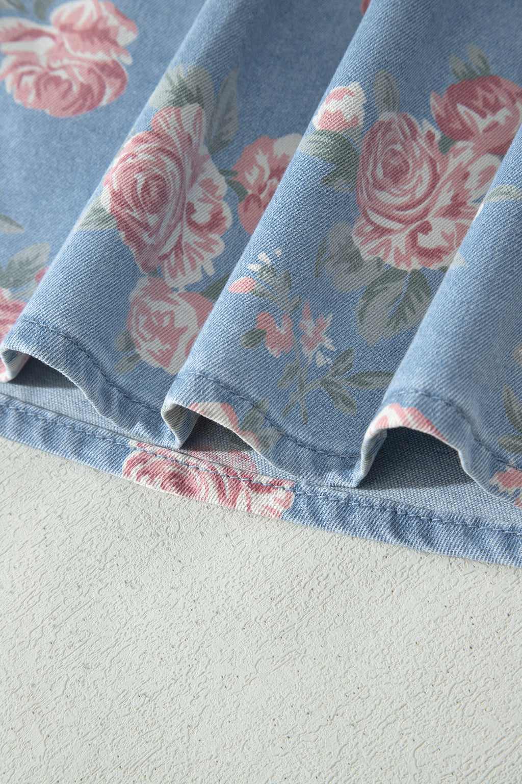 Conjunto de 2 piezas: top de manga corta de mezclilla azul cielo con estampado floral y shorts holgados.