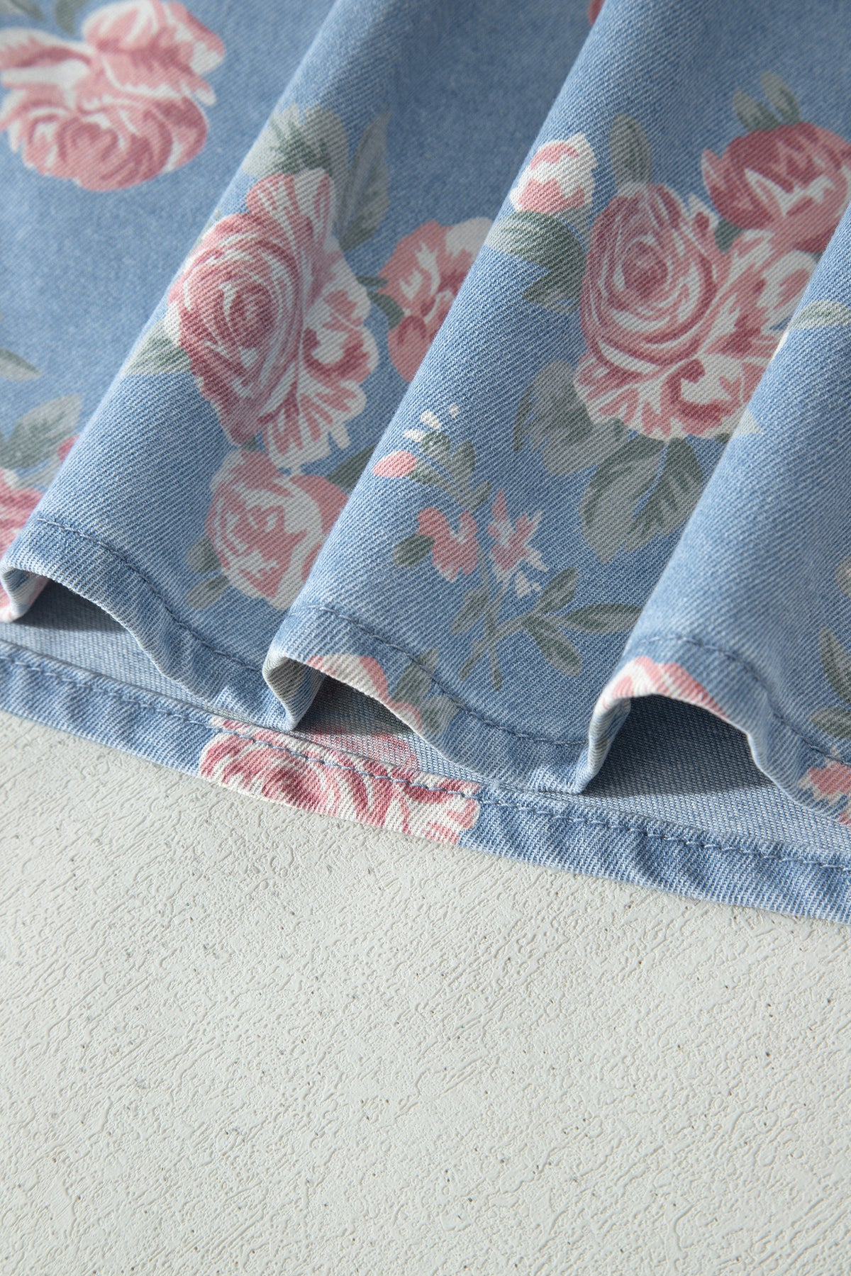 Conjunto de 2 piezas: top de manga corta de mezclilla azul cielo con estampado floral y shorts holgados.