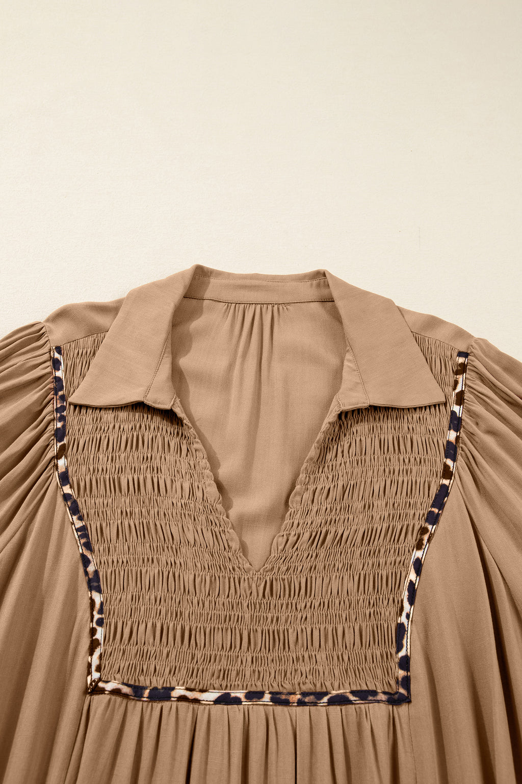 Vestido largo con cuello en V, cuello con trébol de cuatro hojas, detalle fruncido y ribete de leopardo en contraste, mangas tres cuartos.